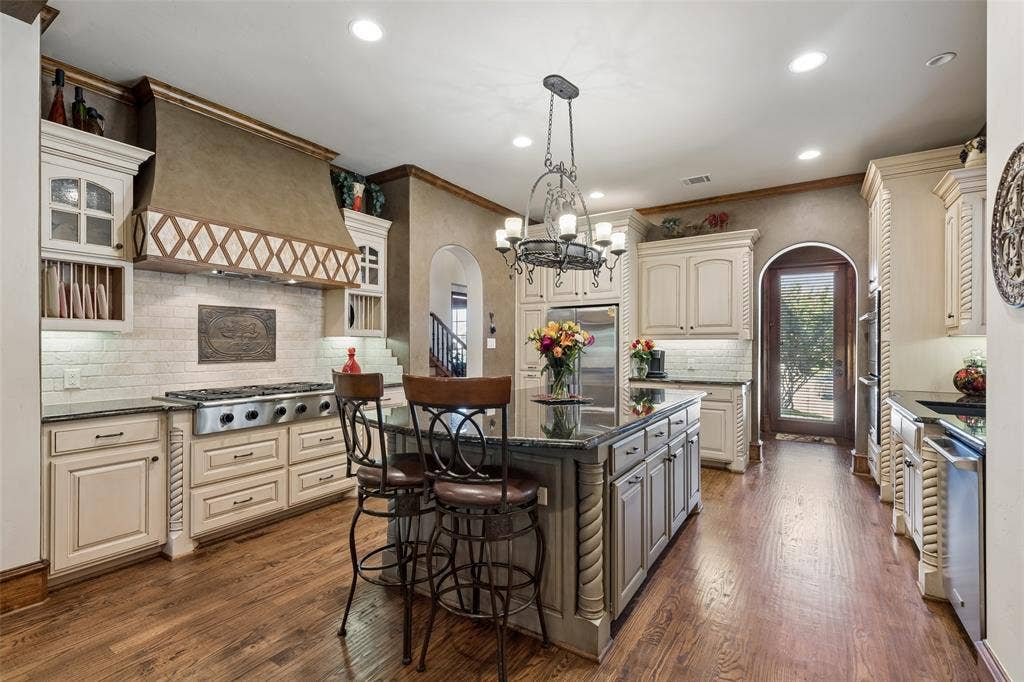125 Audrey Drive, Keller, TX 76248 Large chef kitchen with gas range, double oven, built in microwave, large pantry, granite countertops and hard wood floors.