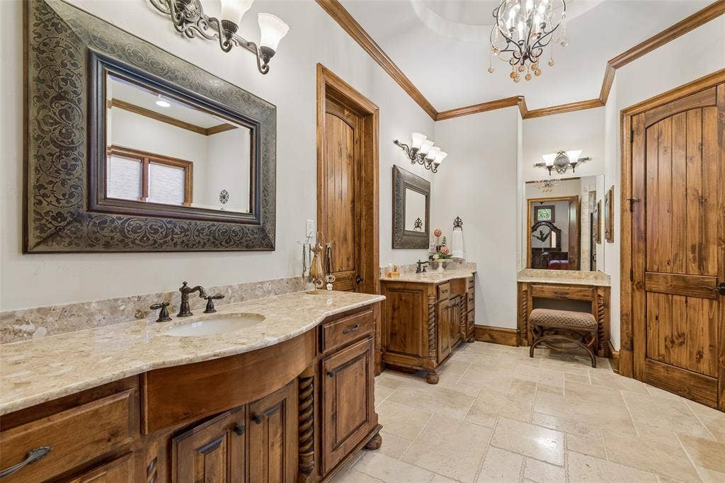 125 Audrey Drive, Keller, TX 76248 Primary bathroom featuring granite countertops, travertine flooring, chandelier, walk in closet, jetted soaking tub, walk in shower and makeup vanity.