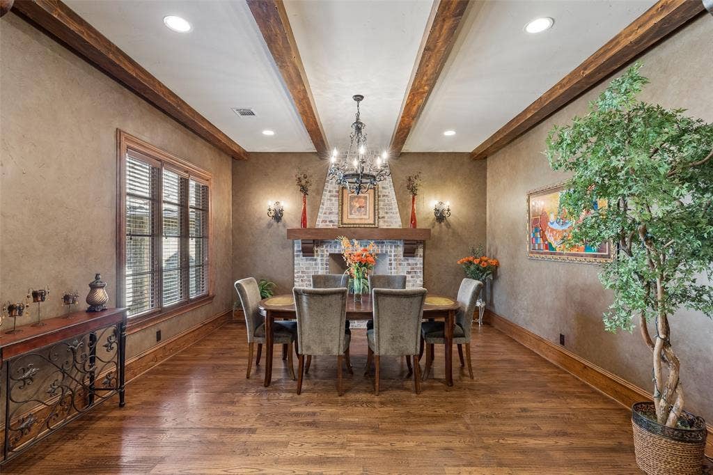 125 Audrey Drive, Keller, TX 76248 Dining Room with beautiful hardwood floors, Large Masonry Isokern Fireplace (Isokern fireplaces by Earthcore are crafted from pure Icelandic volcanic pumice, delivering unmatched insulation and heat refraction), natural light and chandilier.