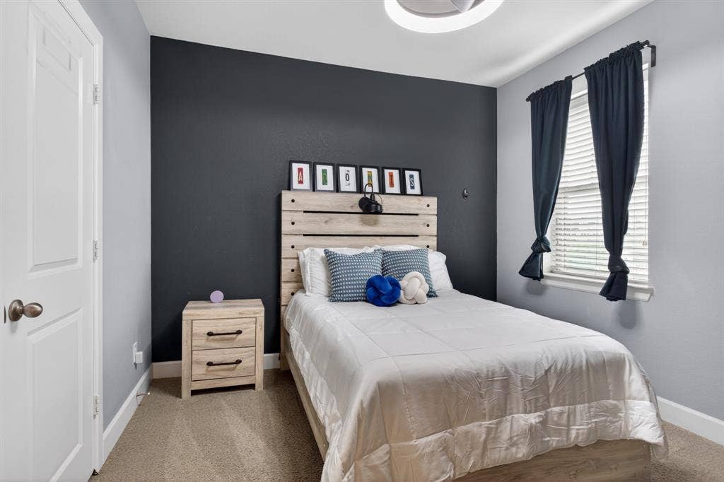 6301 Millie Way, McKinney, TX 75070 Third bedroom featuring a stylish accent wall and abundant natural light, creating a warm and inviting retreat.