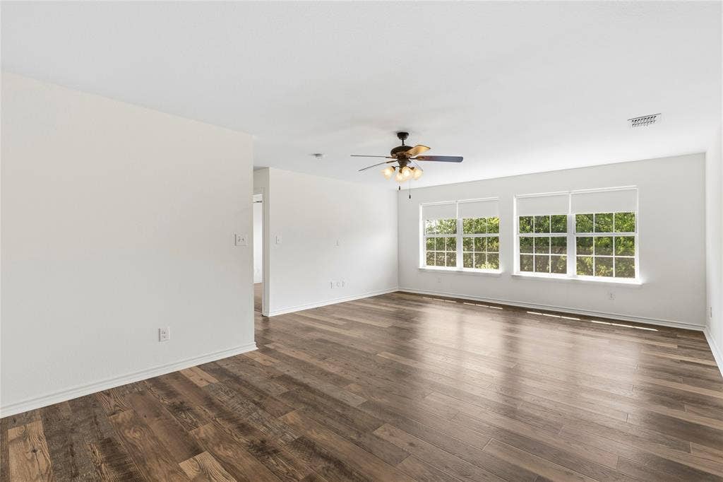 544 Hubbard Circle, Nevada, TX 75173 Spacious interior featuring wood-finish flooring, white walls, and multiple windows with roller shades