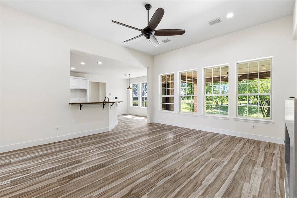 544 Hubbard Circle, Nevada, TX 75173 Spacious living area featuring wood-look tile flooring, a dark-toned ceiling fan, and recessed lighting