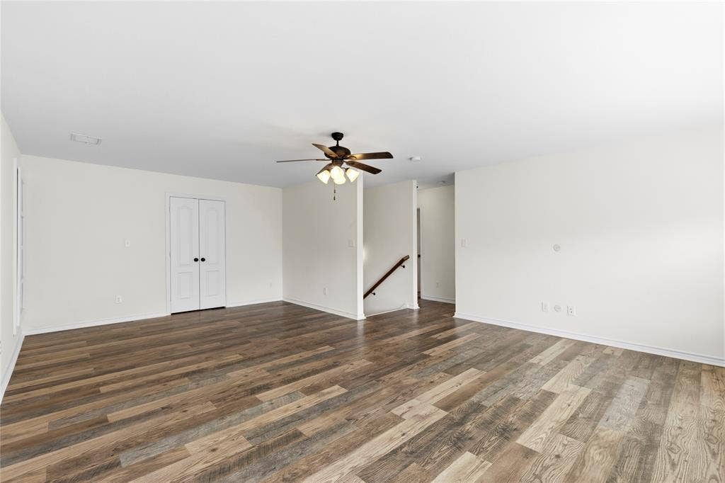 544 Hubbard Circle, Nevada, TX 75173 Spacious room featuring wood-finish flooring, light-toned walls, a ceiling fan with integrated lighting, and white bi-fold closet doors with dark hardware