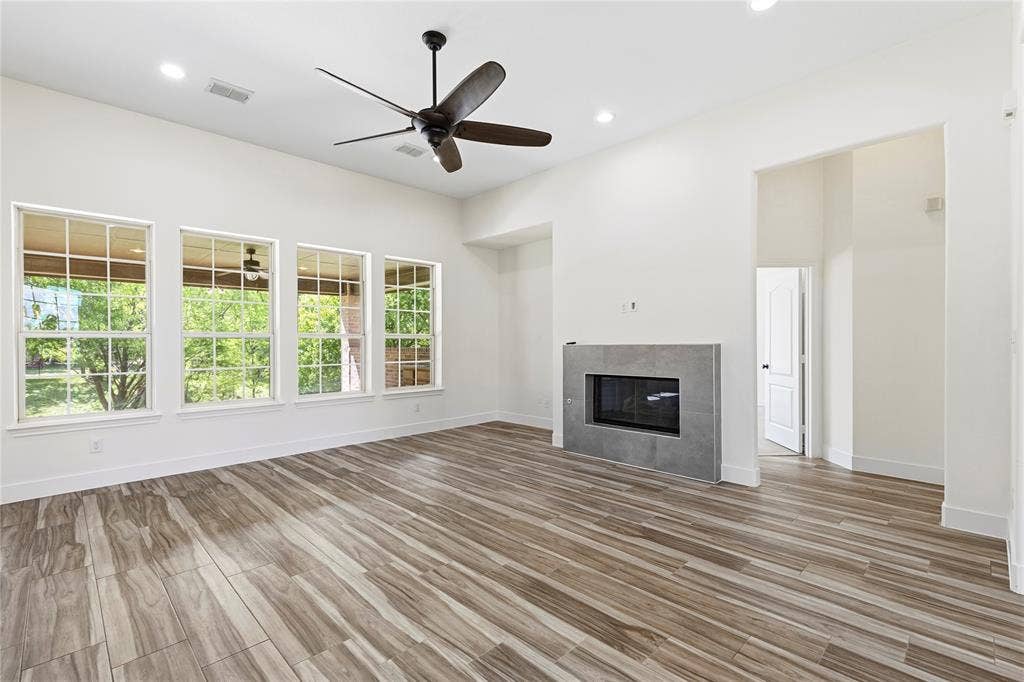 544 Hubbard Circle, Nevada, TX 75173 Spacious interior featuring wood-finish flooring, a modern fireplace with a tiled surround, recessed lighting, and a ceiling fan