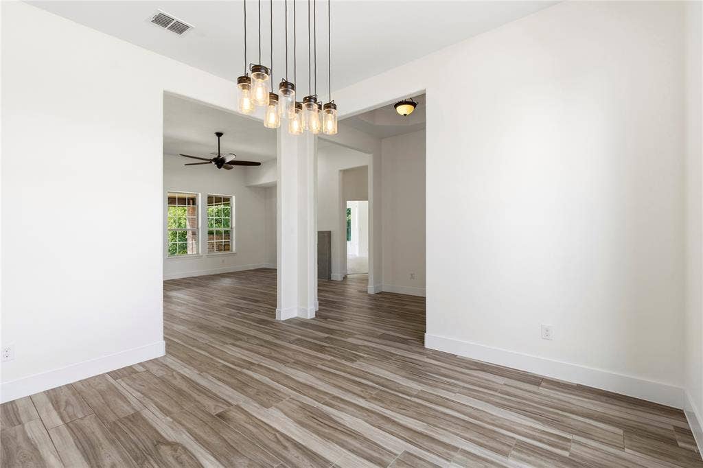 544 Hubbard Circle, Nevada, TX 75173 Open concept space featuring wood-finish flooring, a contemporary chandelier, recessed lighting, and a ceiling fan