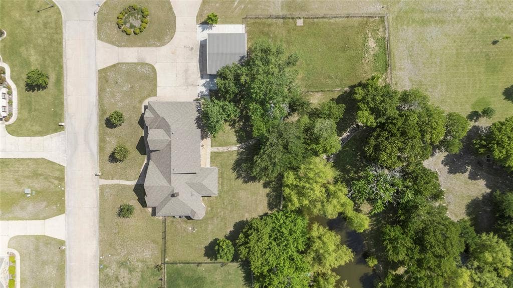 544 Hubbard Circle, Nevada, TX 75173 Property featuring a multi-gabled roofline, an attached paved driveway, and an additional detached structure