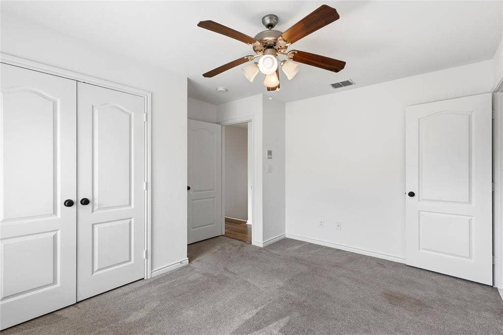 544 Hubbard Circle, Nevada, TX 75173 Carpeted room featuring a ceiling fan with light kit, bi-fold closet doors, white paneled doors, and white baseboards