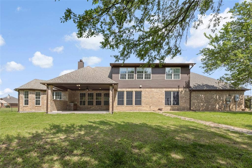 544 Hubbard Circle, Nevada, TX 75173 Expansive brick and siding exterior featuring a covered patio with recessed lighting and a ceiling fan