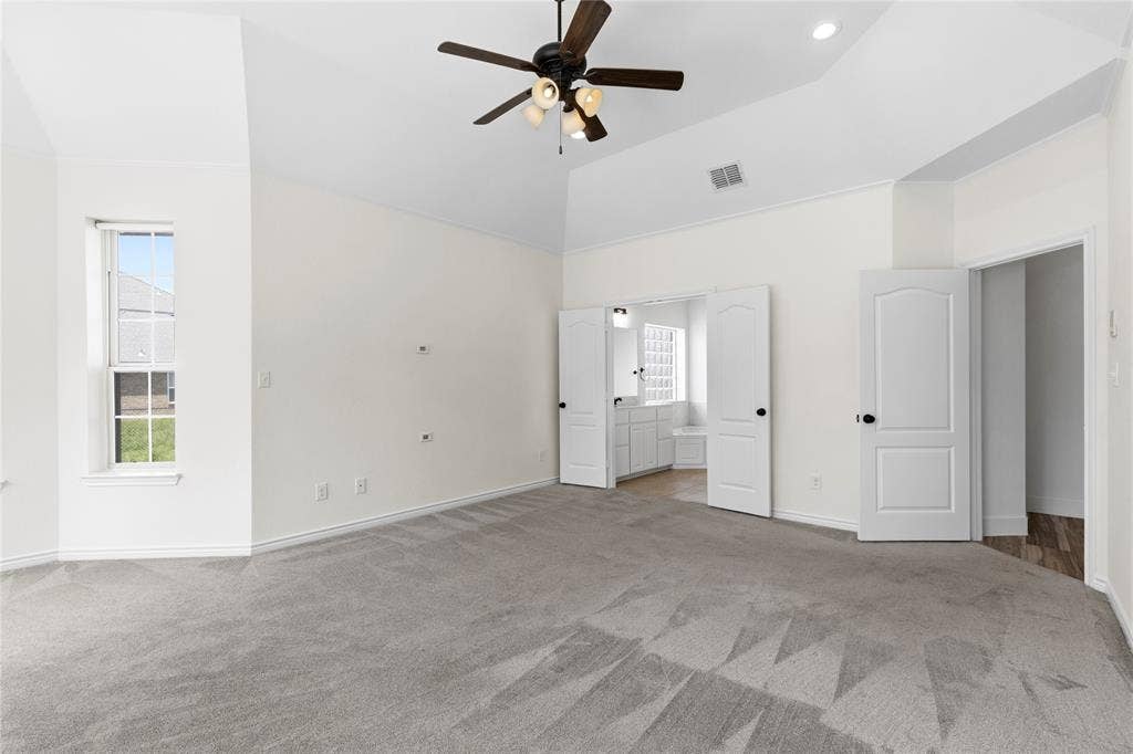 544 Hubbard Circle, Nevada, TX 75173 Spacious room featuring vaulted ceilings, a ceiling fan with light fixture, light gray carpeting, and a window with a white frame