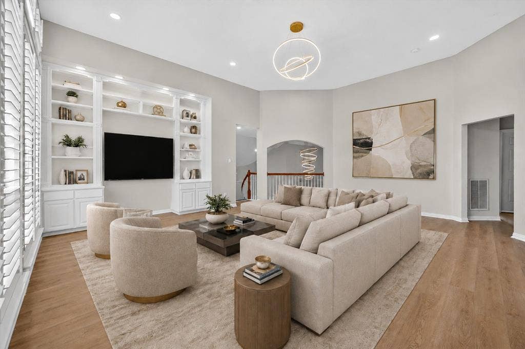 4437 Lone Tree Drive, Plano, TX 75093 Spacious living area featuring high vaulted ceilings, recessed lighting, and wood-finish flooring
