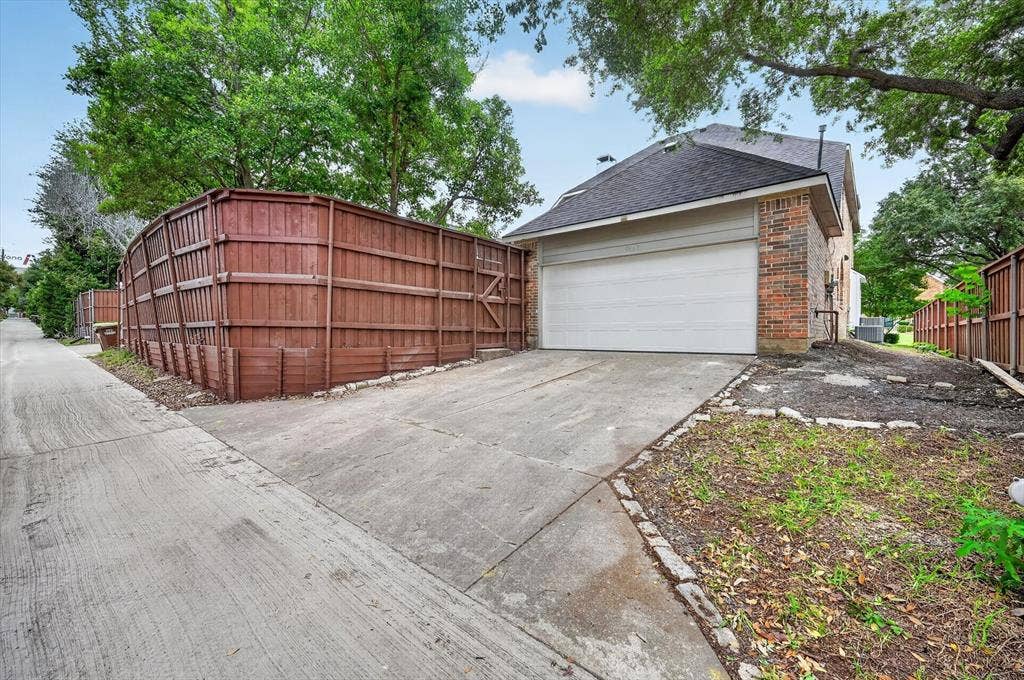 4437 Lone Tree Drive, Plano, TX 75093 Side-entry garage with an attached concrete driveway, brick exterior, and a dark shingle roof