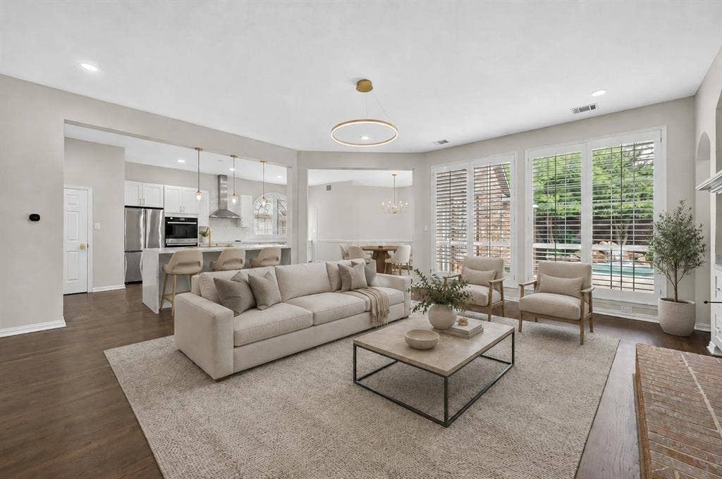 4437 Lone Tree Drive, Plano, TX 75093 Spacious living area featuring dark wood-finish flooring, a contemporary chandelier, and recessed lighting