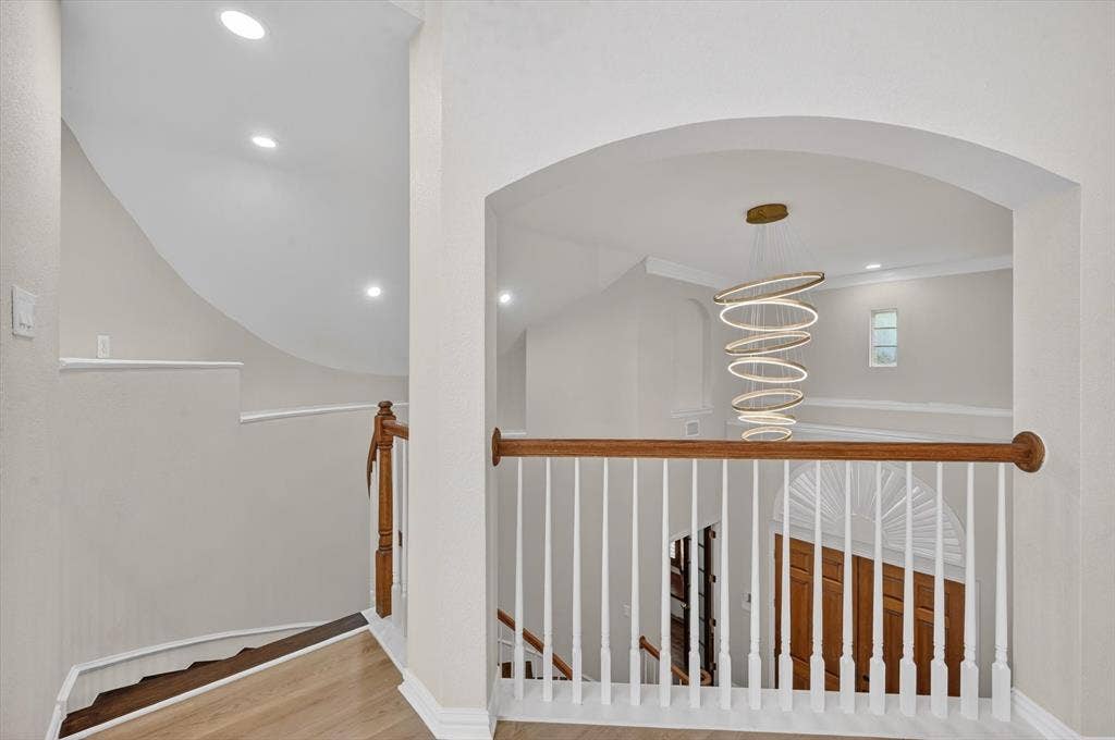4437 Lone Tree Drive, Plano, TX 75093 Upper landing featuring light wood-finish flooring and an arched entryway