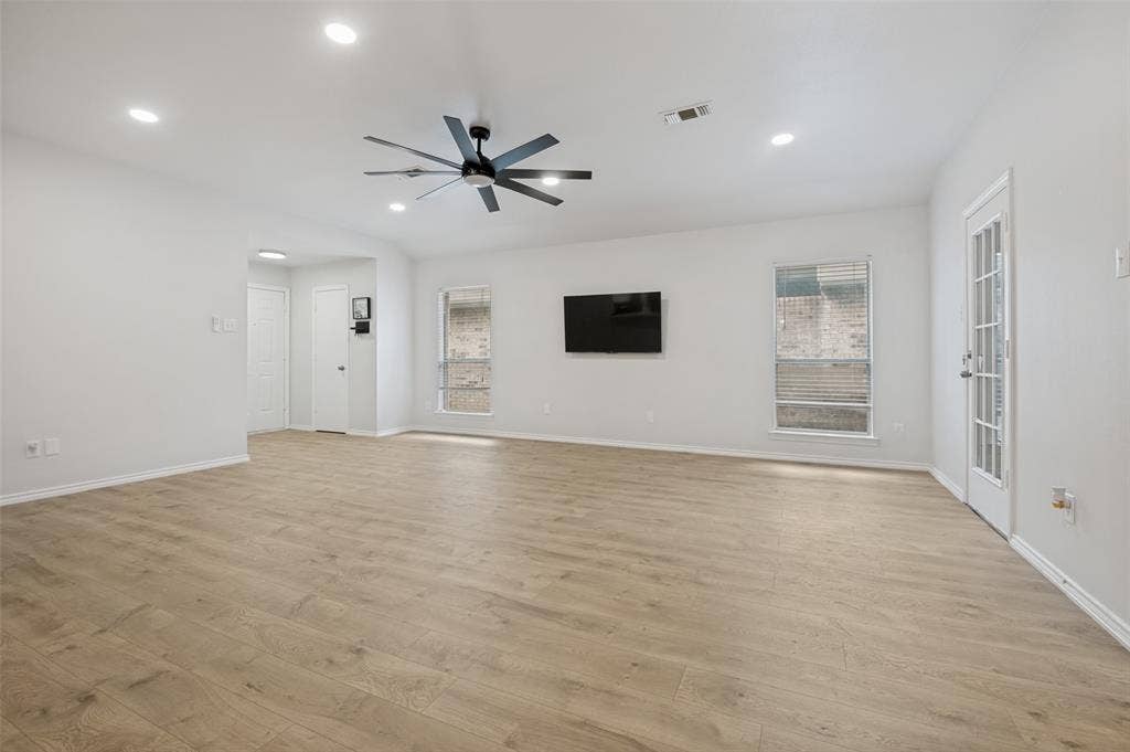 Spacious room featuring wood-finish flooring, recessed lighting, and a contemporary ceiling fan