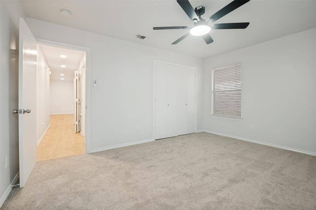 Neutral-toned interior room featuring light gray carpeting and white walls