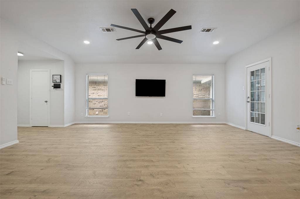 Expansive living area featuring light wood-finish flooring, recessed lighting, and a contemporary ceiling fan