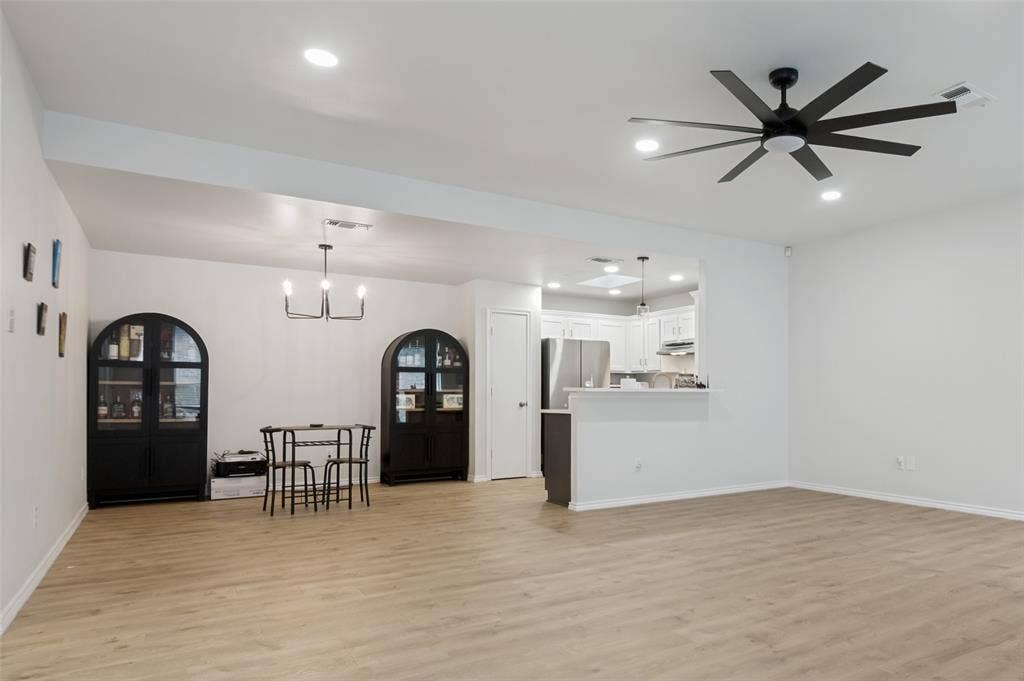 Open-concept living area featuring light wood-finish flooring, recessed lighting, and a contemporary ceiling fan
