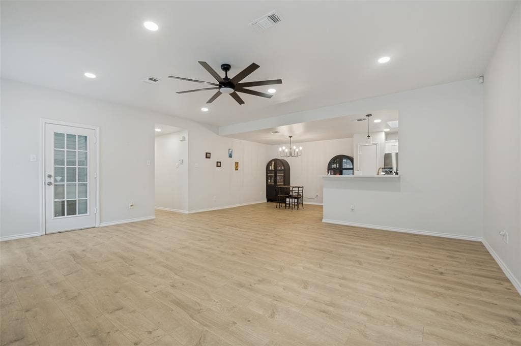 Open-concept living area featuring wood-finish flooring, recessed lighting, and a modern ceiling fan