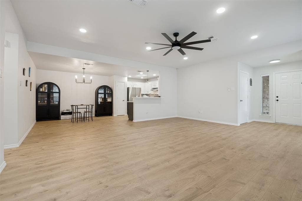 Spacious living area featuring wood-finish flooring, recessed lighting, and a contemporary ceiling fan