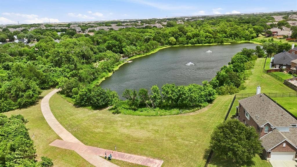 201 Fountainview Drive, Euless, TX 76039 The McCormick Pond Preserve sits adjacent to home and features a paved walking path, mature trees, and a freshwater pond with visible fountains and a fishing pier.