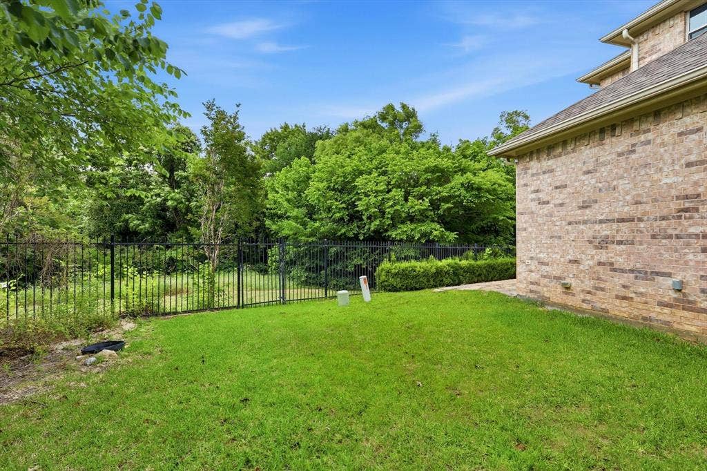 201 Fountainview Drive, Euless, TX 76039 Expansive green lawn adorned with a wrought iron fence provides ample space for all of your outdoor activies.