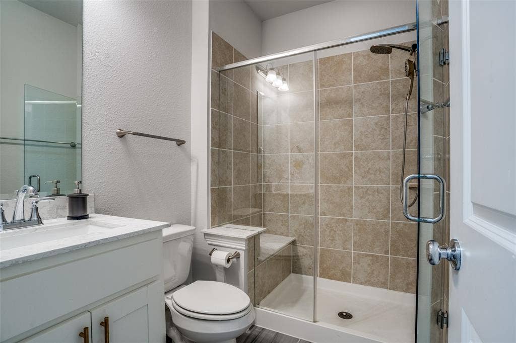 2811 Killdeer Trail, Prosper, TX 75078 Full bathroom featuring a textured wall, vanity, and a shower stall