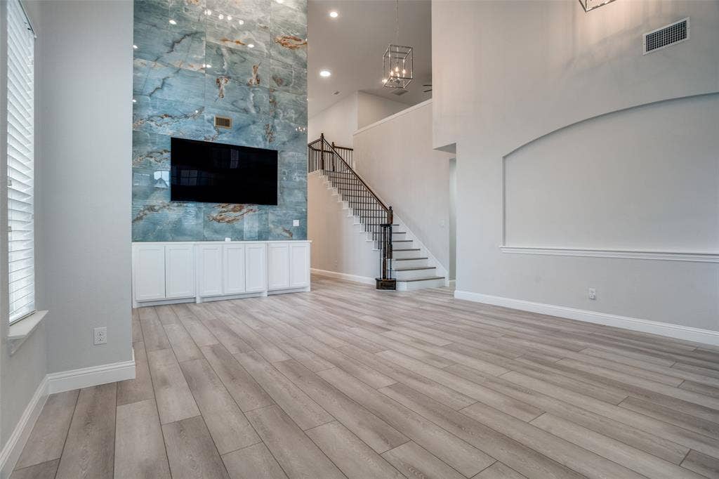 2811 Killdeer Trail, Prosper, TX 75078 Unfurnished living room featuring light wood finished floors and a high ceiling