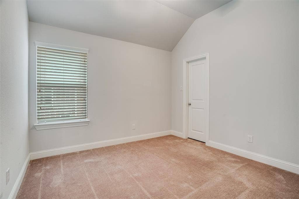 2811 Killdeer Trail, Prosper, TX 75078 Empty room with vaulted ceiling and light colored carpet