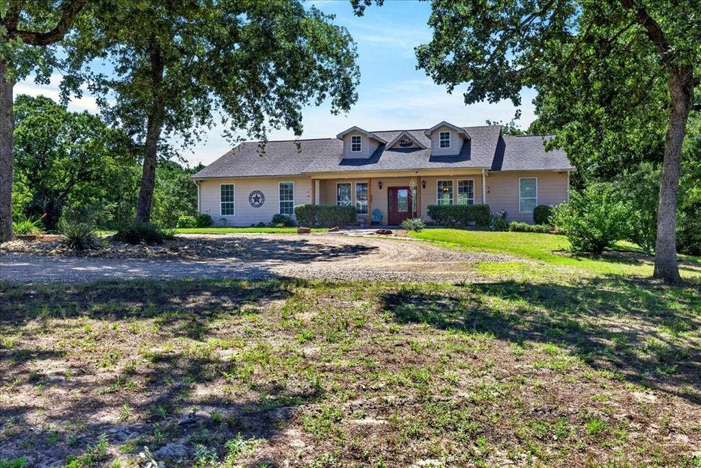11591 Fm 59, Athens, TX 75751 Ranch-style residence featuring a covered front porch, multiple dormer windows, and a prominent red front door. Come sit awhile at 11595 FM 59, Athens TX 75751.