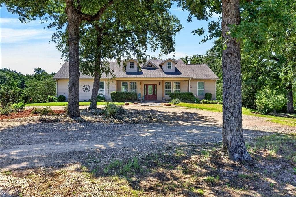 11591 Fm 59, Athens, TX 75751 Traditional-style residence featuring a dormer roofline, covered porch, and a gravel driveway