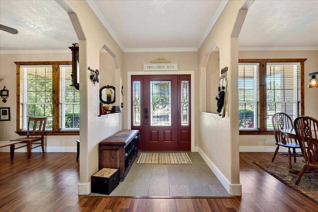 11591 Fm 59, Athens, TX 75751 Entryway featuring a decorative transom, leaded glass sidelights, and a rich red front door. Flex space/Office is on the right and dining area is on the left.