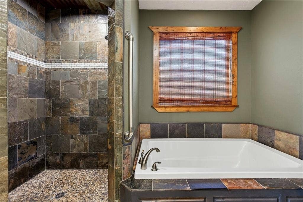 11591 Fm 59, Athens, TX 75751 Walk-in shower with natural stone tile and pebble flooring, oversize soaker tub.