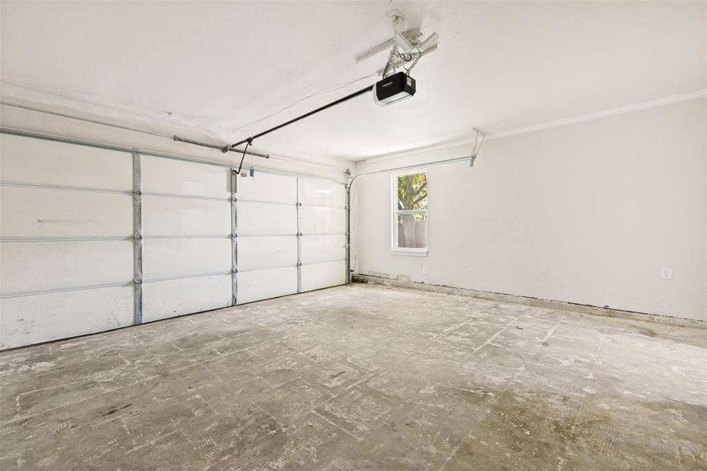 713 Bridgewater Lane, Mesquite, TX 75181 Spacious garage featuring a paneled overhead door, an automatic opener, a single window, and concrete flooring