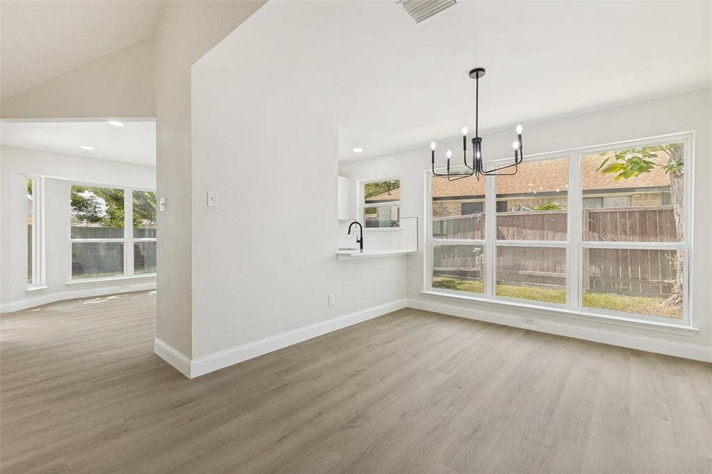 713 Bridgewater Lane, Mesquite, TX 75181 Spacious interior featuring light wood-finish flooring and a contemporary black chandelier