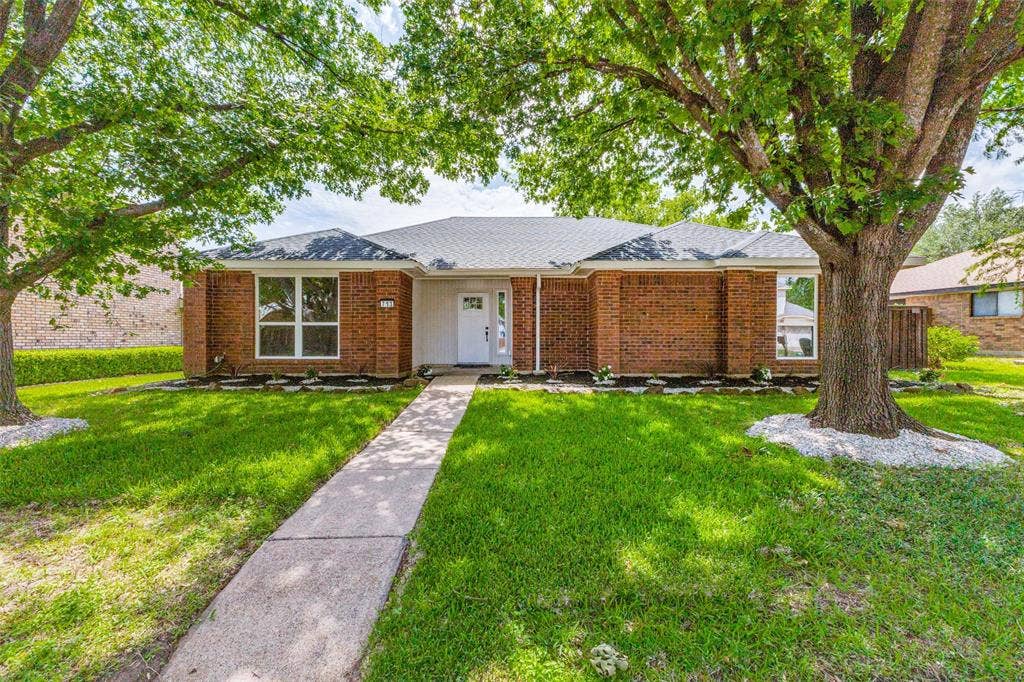 713 Bridgewater Lane, Mesquite, TX 75181 Brick facade residence featuring a gray shingle roof and a concrete walkway
