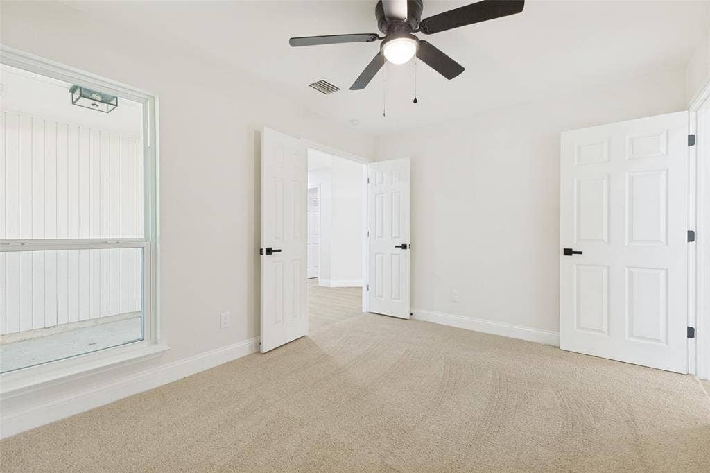 713 Bridgewater Lane, Mesquite, TX 75181 Bright interior space featuring light-toned carpeting, white walls, and a ceiling fan with integrated lighting