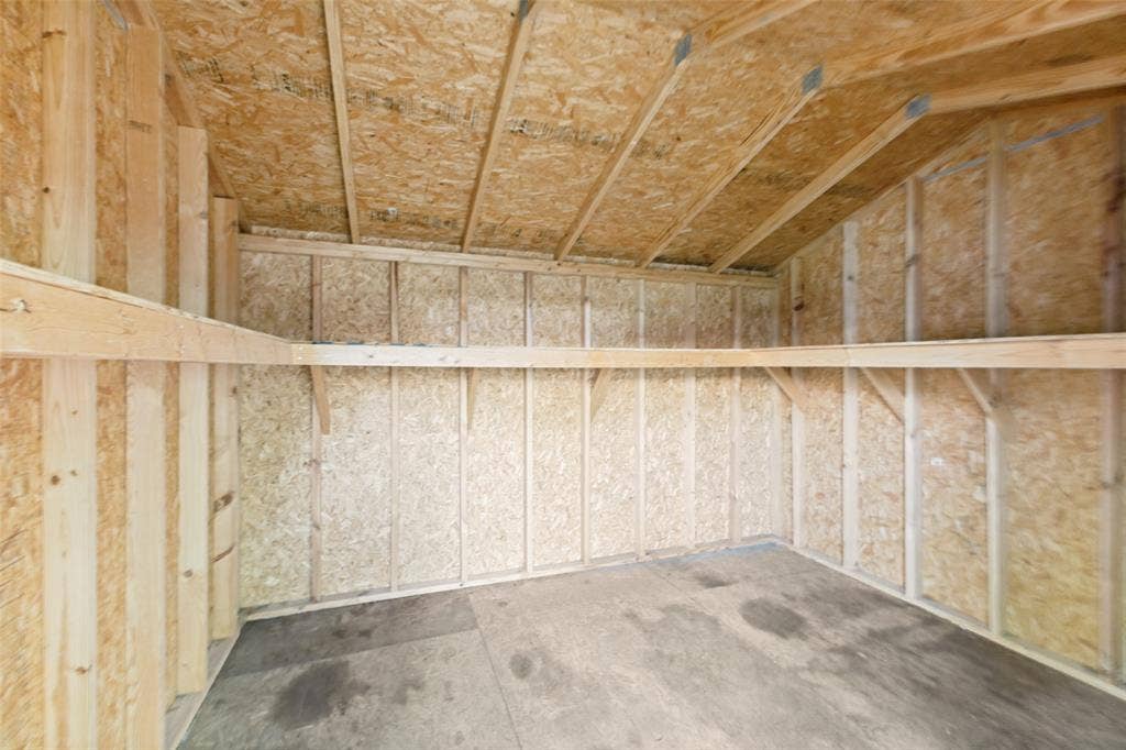 713 Bridgewater Lane, Mesquite, TX 75181 Interior structure featuring wood framing and OSB paneling, concrete flooring, and built-in wood shelving
