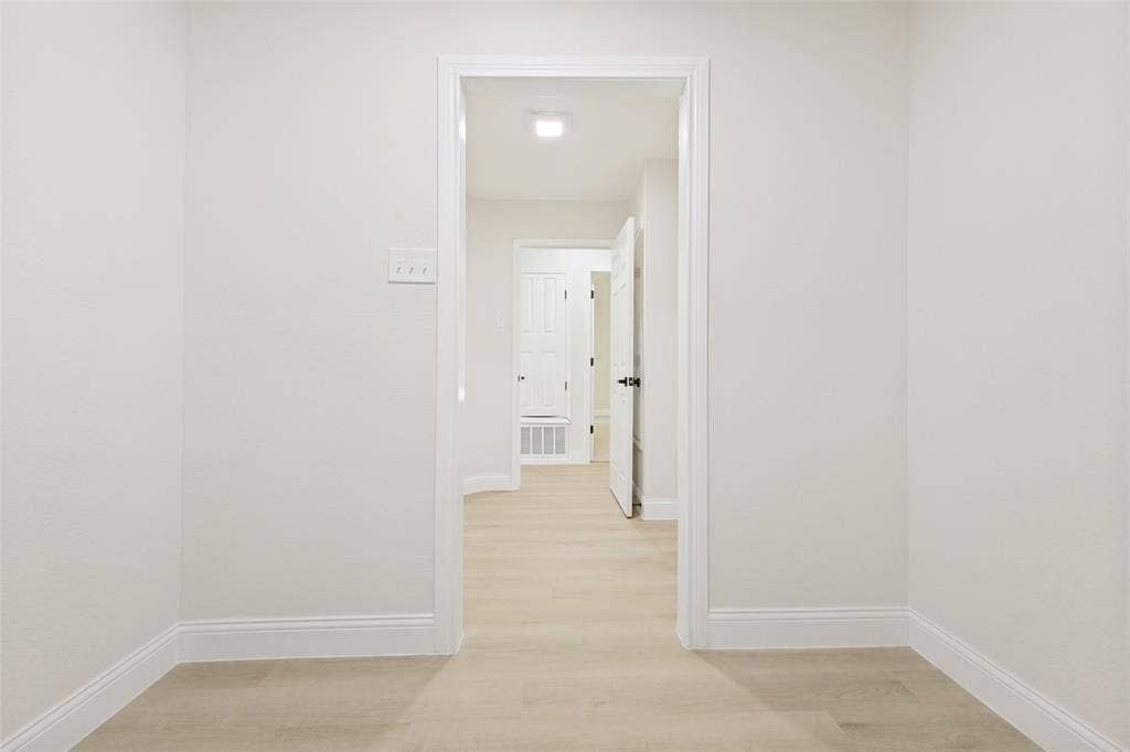 713 Bridgewater Lane, Mesquite, TX 75181 Hallway featuring light wood-finish flooring, white walls, and white baseboards