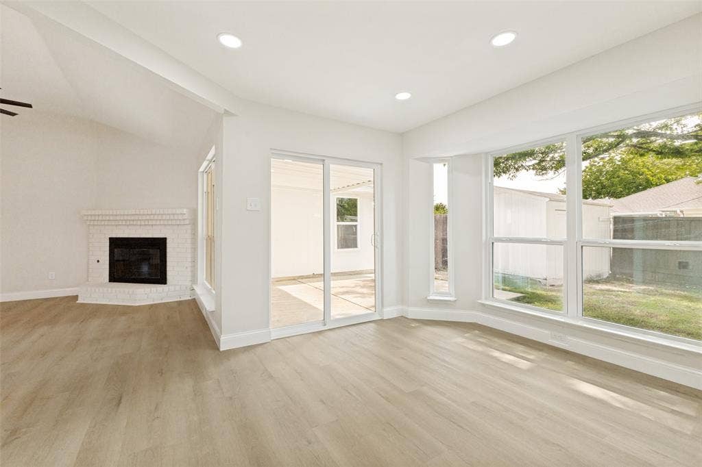 713 Bridgewater Lane, Mesquite, TX 75181 Spacious interior featuring light wood-finish flooring, recessed lighting, and a white brick fireplace