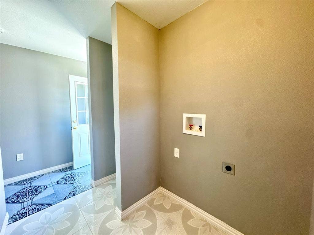 Utility space featuring light gray walls and patterned tile flooring