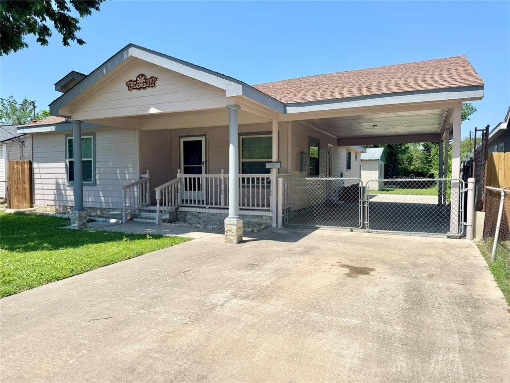 Exterior featuring a covered front porch with pillar accents and a carport