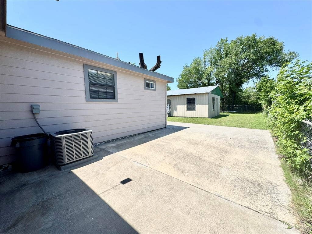 Concrete patio area with a light-colored siding exterior