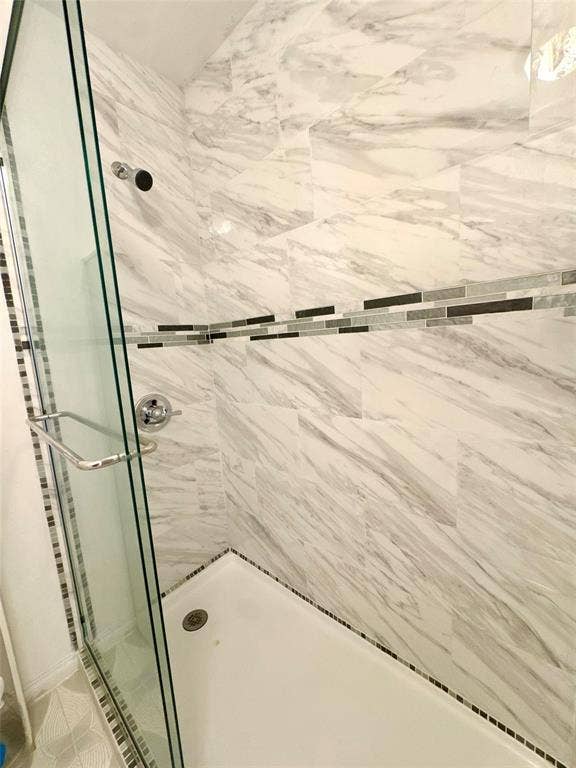 Shower enclosure with glass paneling and chrome hardware