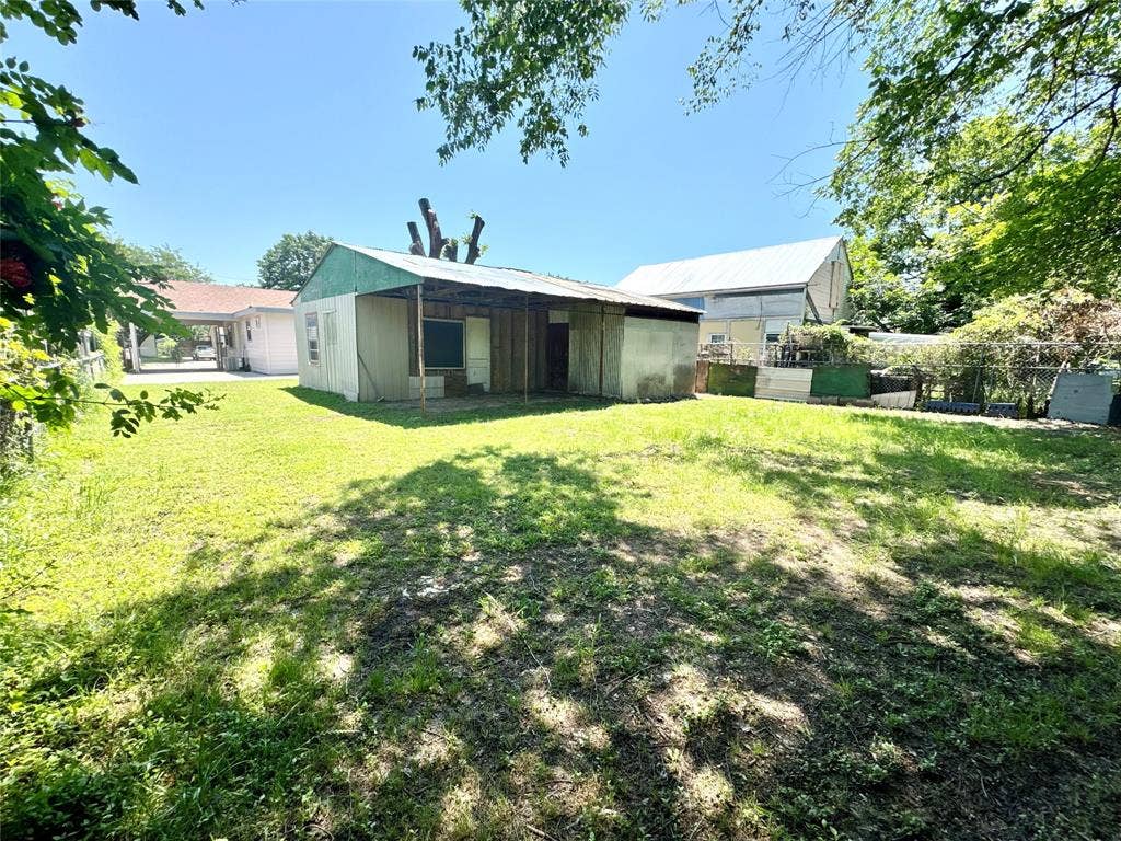 Expansive outdoor space featuring a large grassy lawn and mature trees