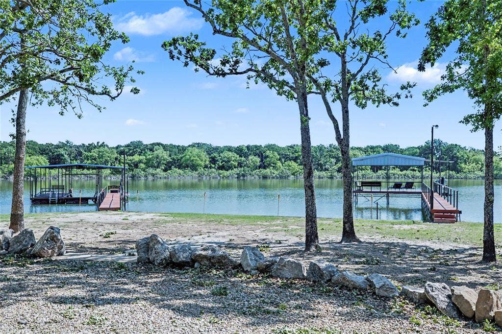 101 Friendship Circle, West Tawakoni, TX 75474 Waterfront property featuring two covered boat docks, each with a wooden walkway