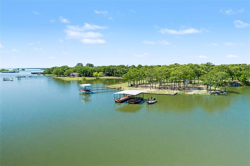 101 Friendship Circle, West Tawakoni, TX 75474 Waterfront property featuring multiple boat docks, a covered boat slip, and a forested shoreline