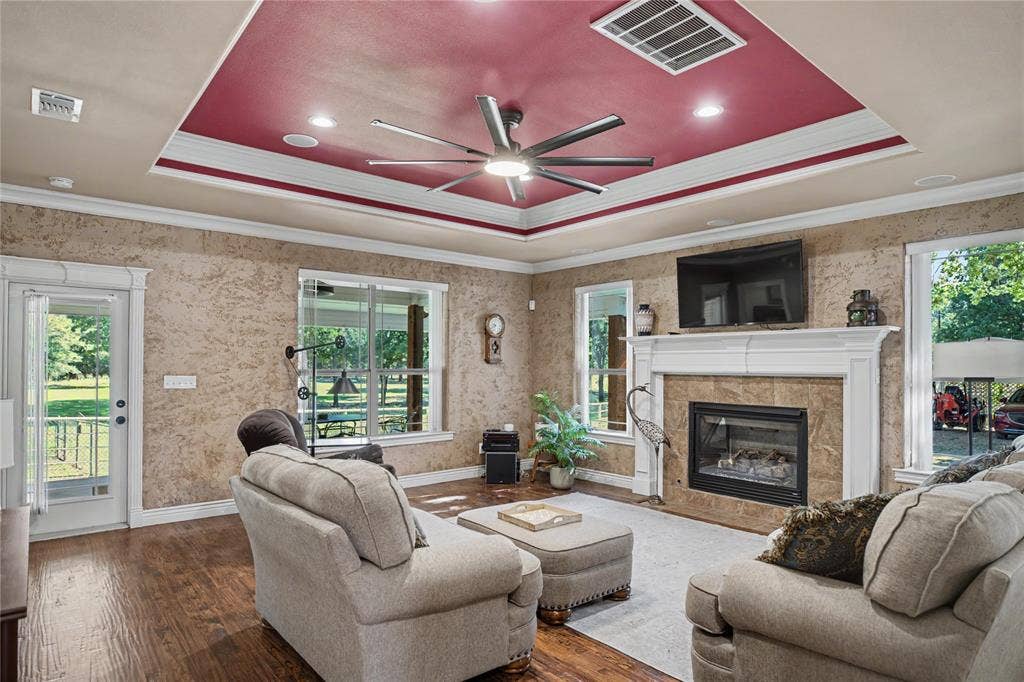 101 Friendship Circle, West Tawakoni, TX 75474 Living area featuring wood-finish flooring, a tray ceiling with recessed lighting and a ceiling fan, and multiple windows