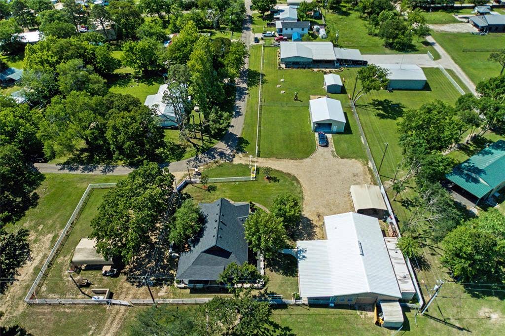 101 Friendship Circle, West Tawakoni, TX 75474 Expansive property featuring a main residence with a dark shingle roof, accompanied by multiple outbuildings including a large metal structure with a silver roof, and a smaller metal building