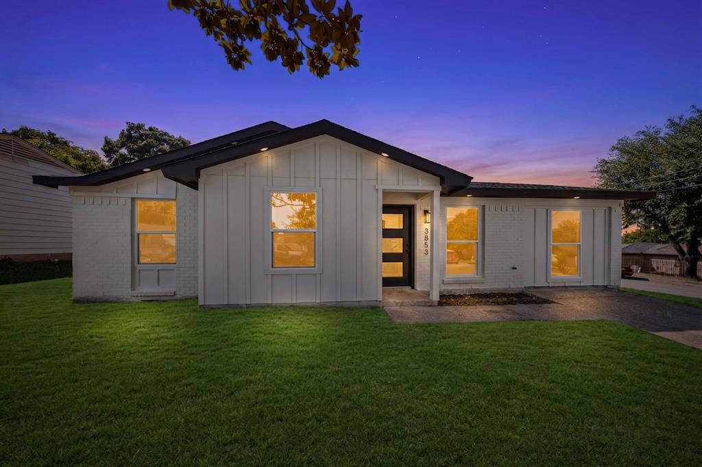 3853 Happy Canyon Drive, Dallas, TX 75241 Contemporary-style home featuring a dark shingle roof, white vertical siding, and a contrasting dark entry door with horizontal glass panels