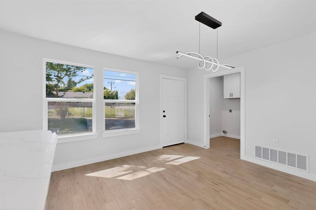 3853 Happy Canyon Drive, Dallas, TX 75241 Open-concept room featuring wood-finish flooring, a modern linear chandelier, and a white interior door